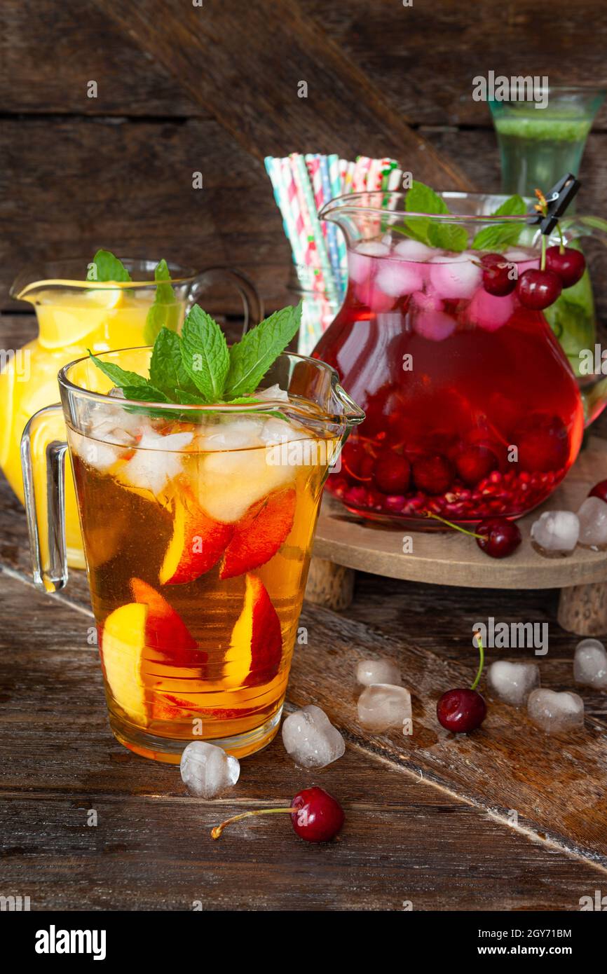 Ice cold beverages with fresh fruits in glass pitchers Stock Photo