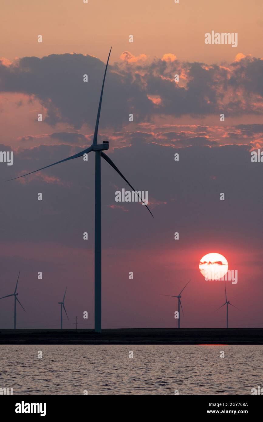 Silhouettes of wind turbines farm Behind the Lake at Sunset Stock Photo ...