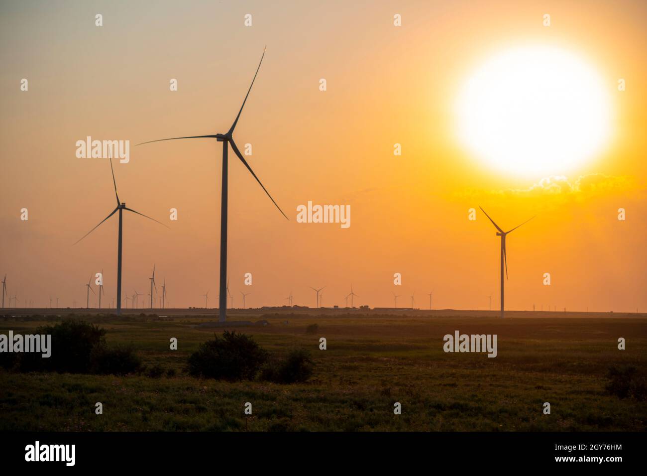 Silhouettes of wind turbines farm Behind the Lake at Sunset Stock Photo ...