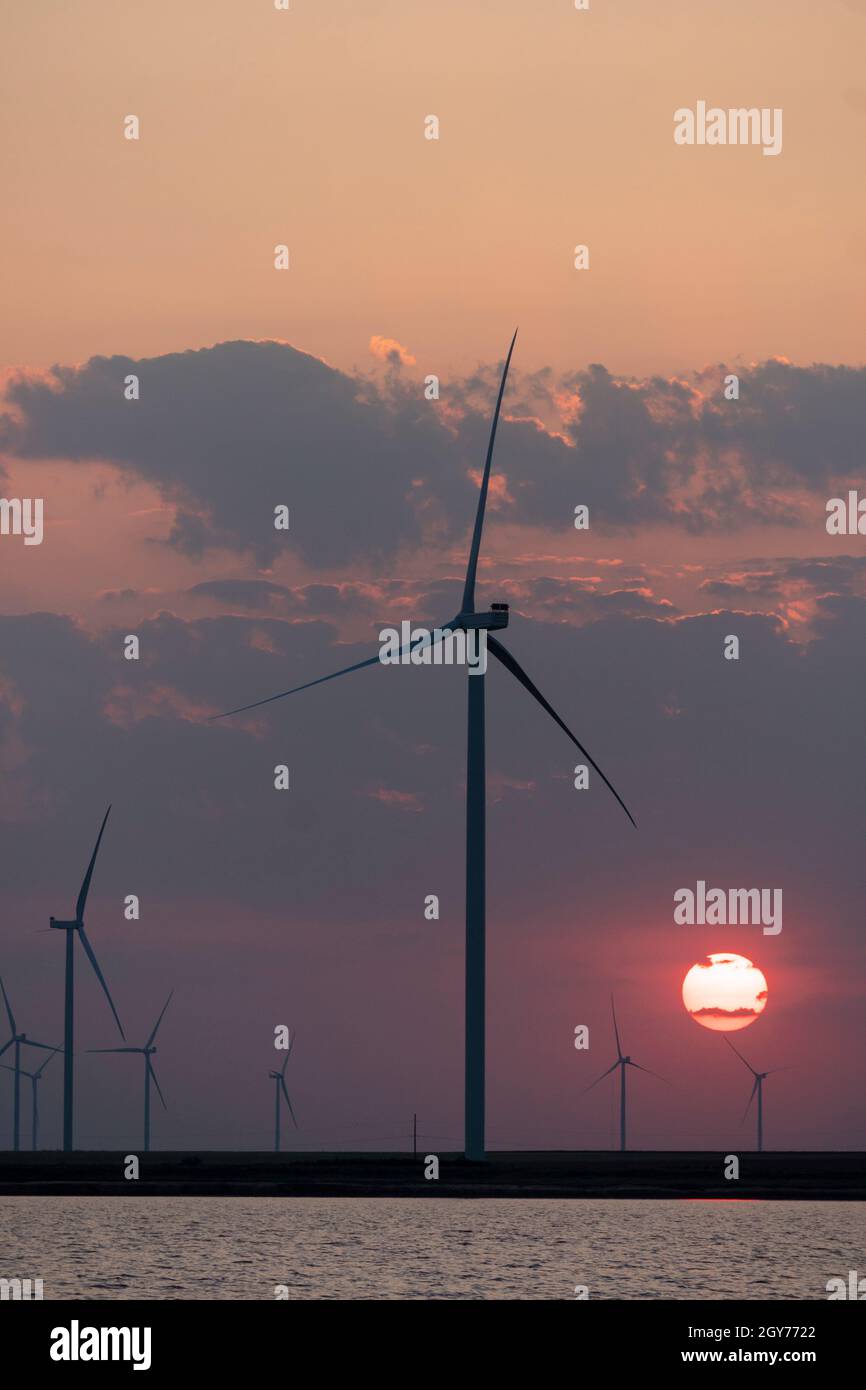 Silhouettes of wind turbines farm Behind the Lake at Sunset Stock Photo ...