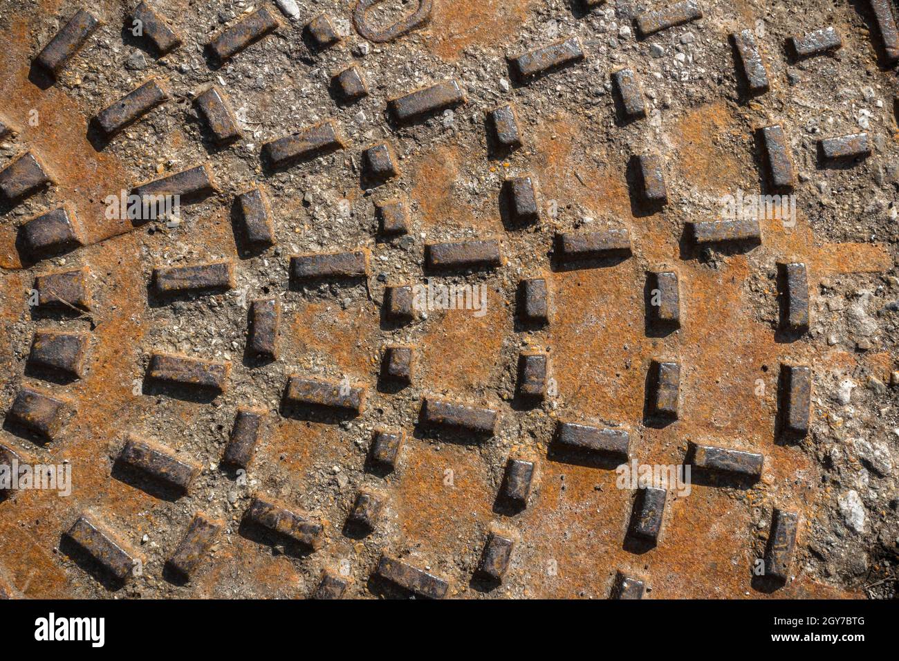Rusty sewer manhole cover. Geometric pattern on the cover of the sewer ...