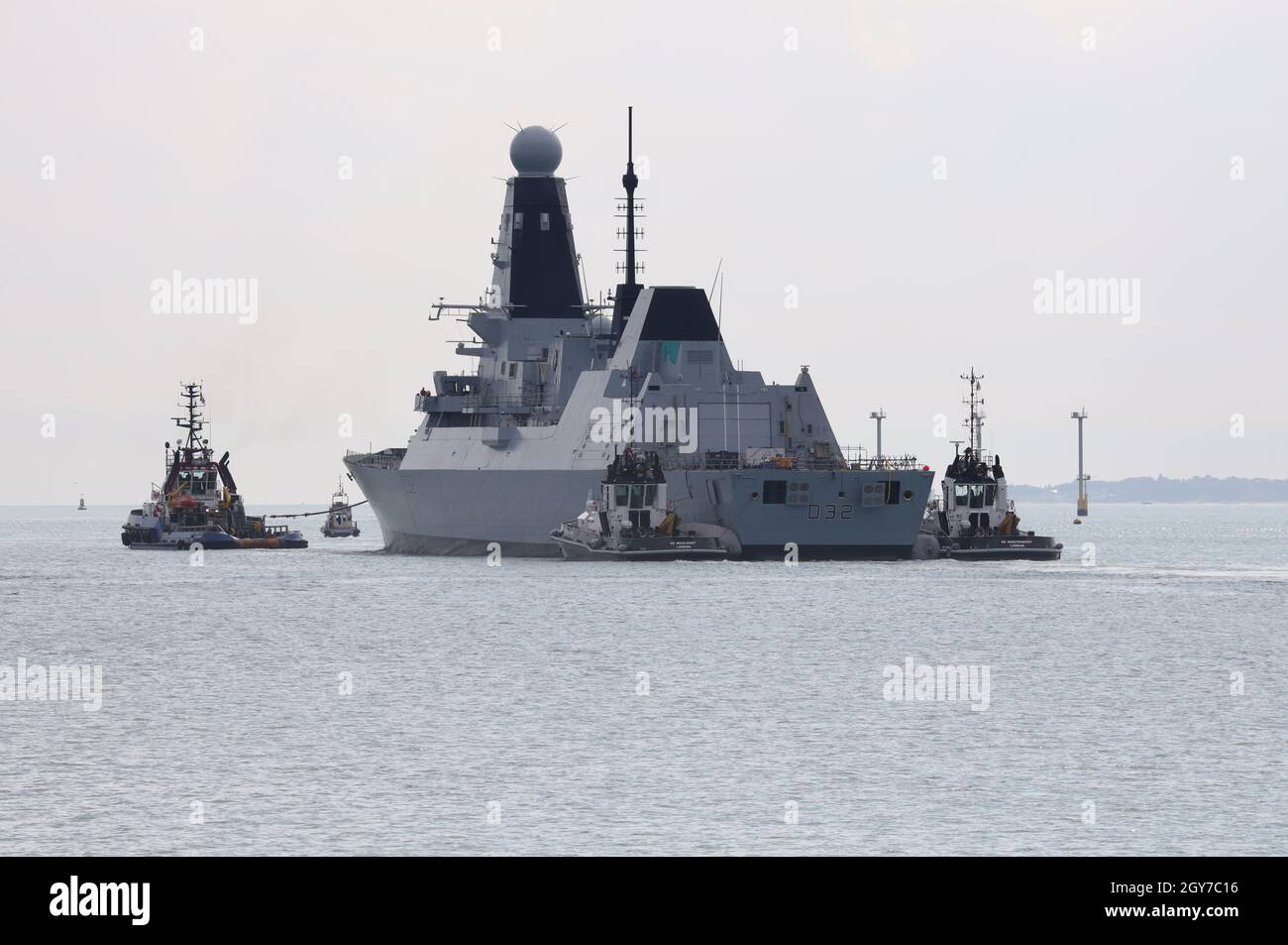 Tugs guide the Royal Navy Type 45 destroyer HMS DARING into The Solent Stock Photo