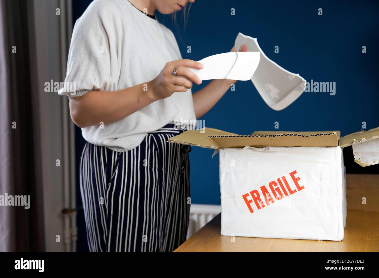 Young woman opening damaged delivery package,online shopping package ...