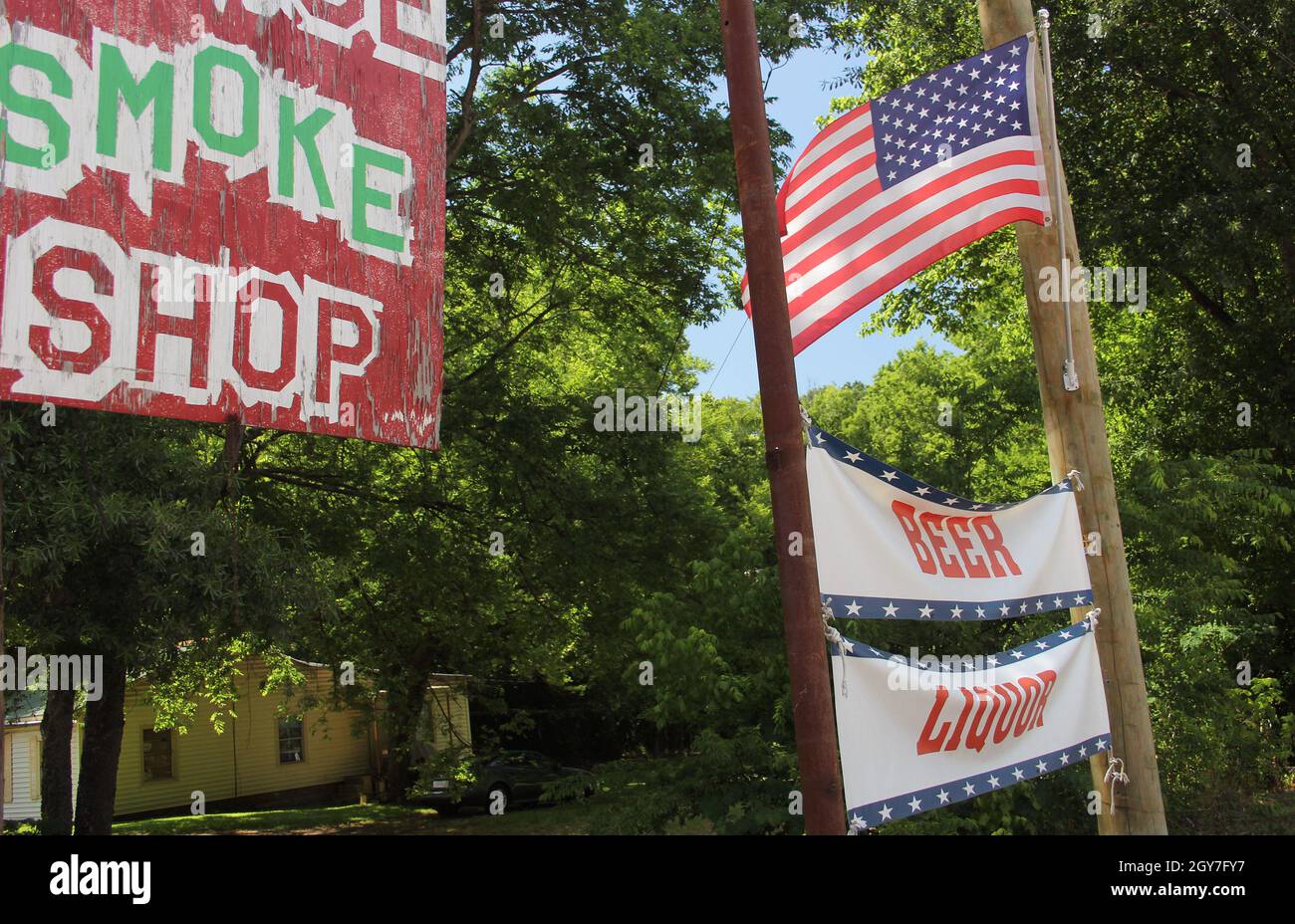 Smoke Shop Sign Next to Beer and Liquor sign with American Flag. Rural Texas Scenery. Small Town Texas Stock Photo