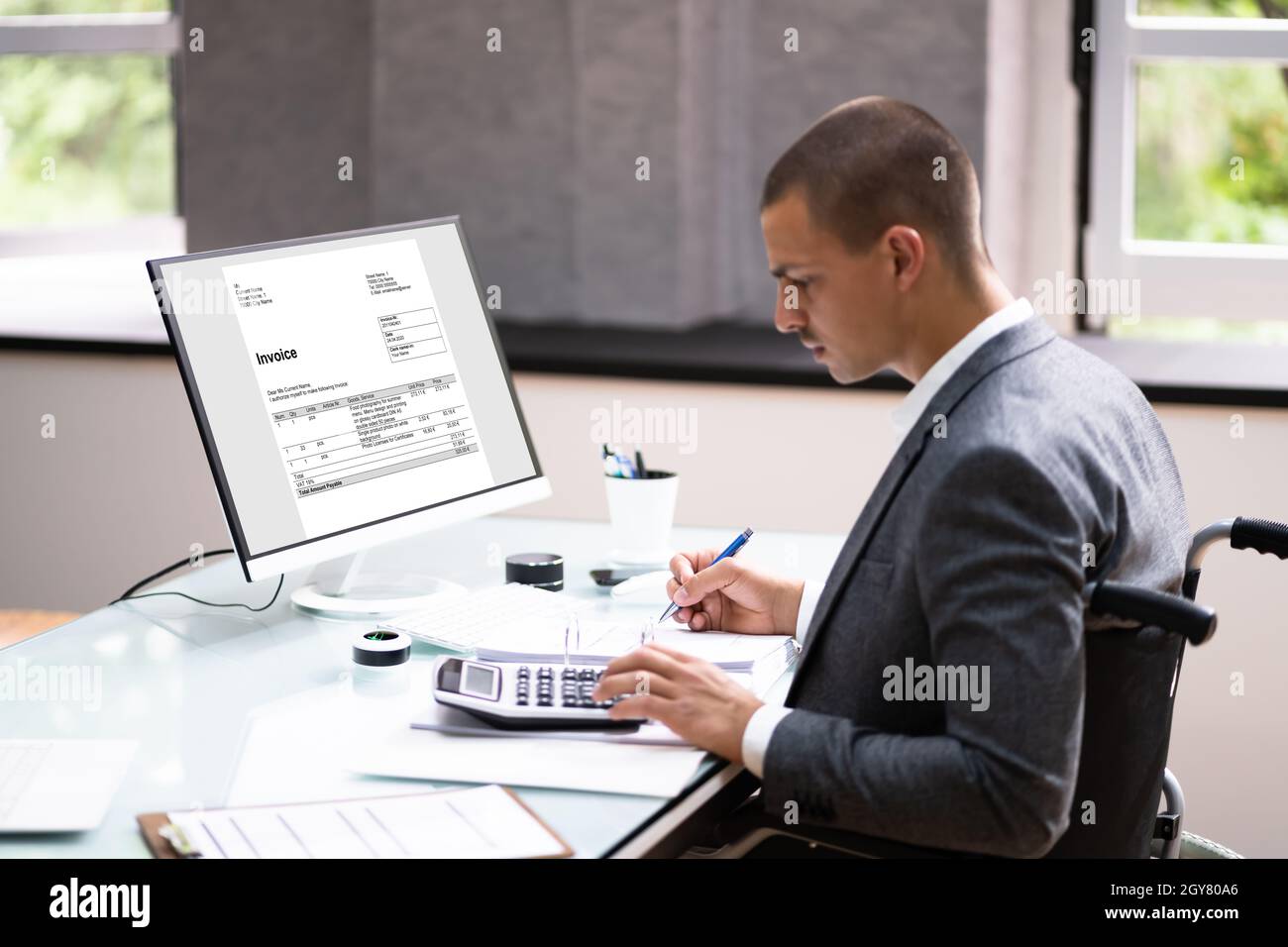 Disabled Accountant In Wheelchair Working Using Computer Stock Photo