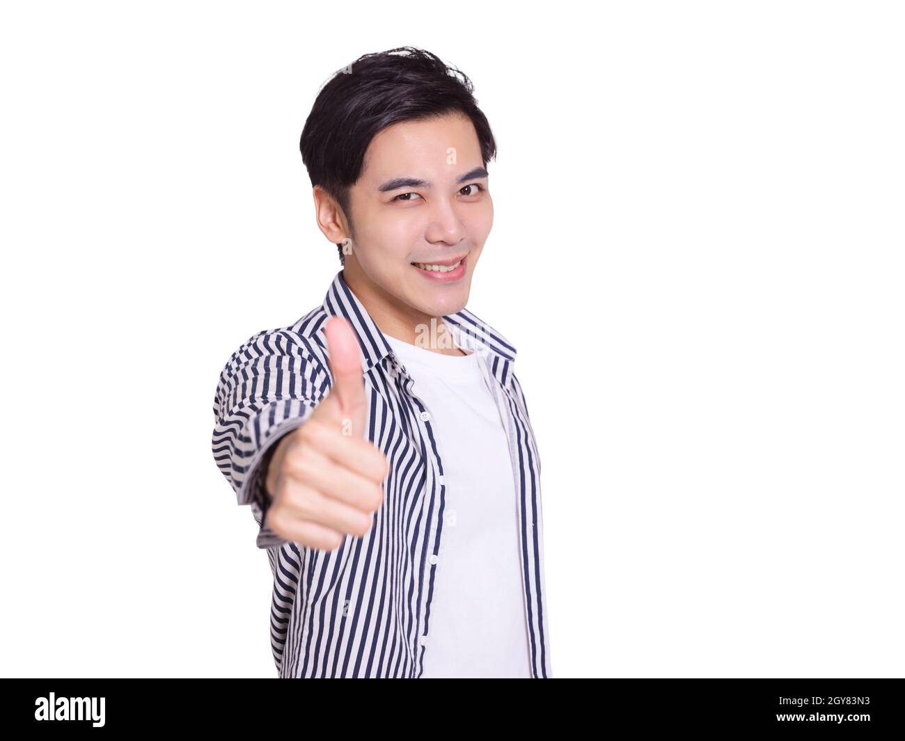 young man smiling and making thumbs up gesture Stock Photo