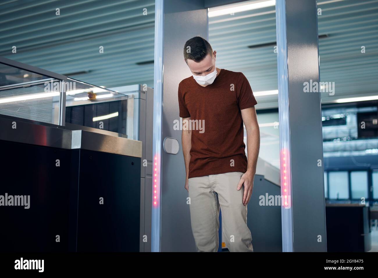 Security checkpoint at airport. Passengers passing through gate of metal detector. Stock Photo