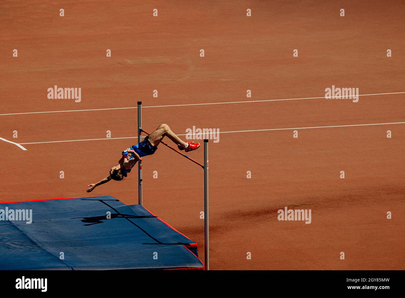 high jump male athlete jump at athletics competition Stock Photo