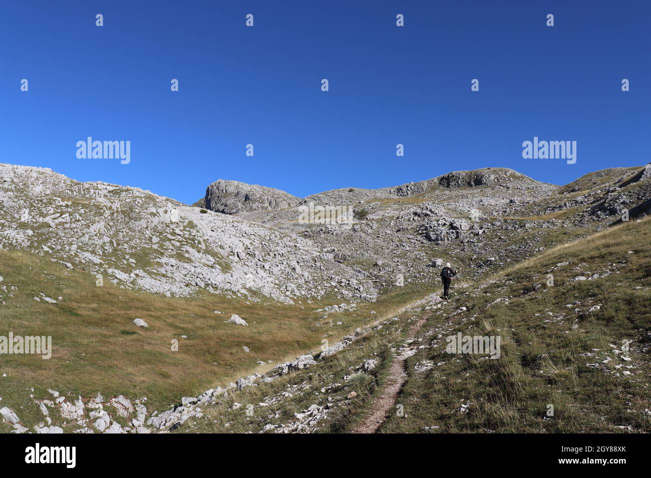Rocky slopes and talus on Mount Visocica in Bosnia and Herzegovina and a moving mountaineer Stock Photo