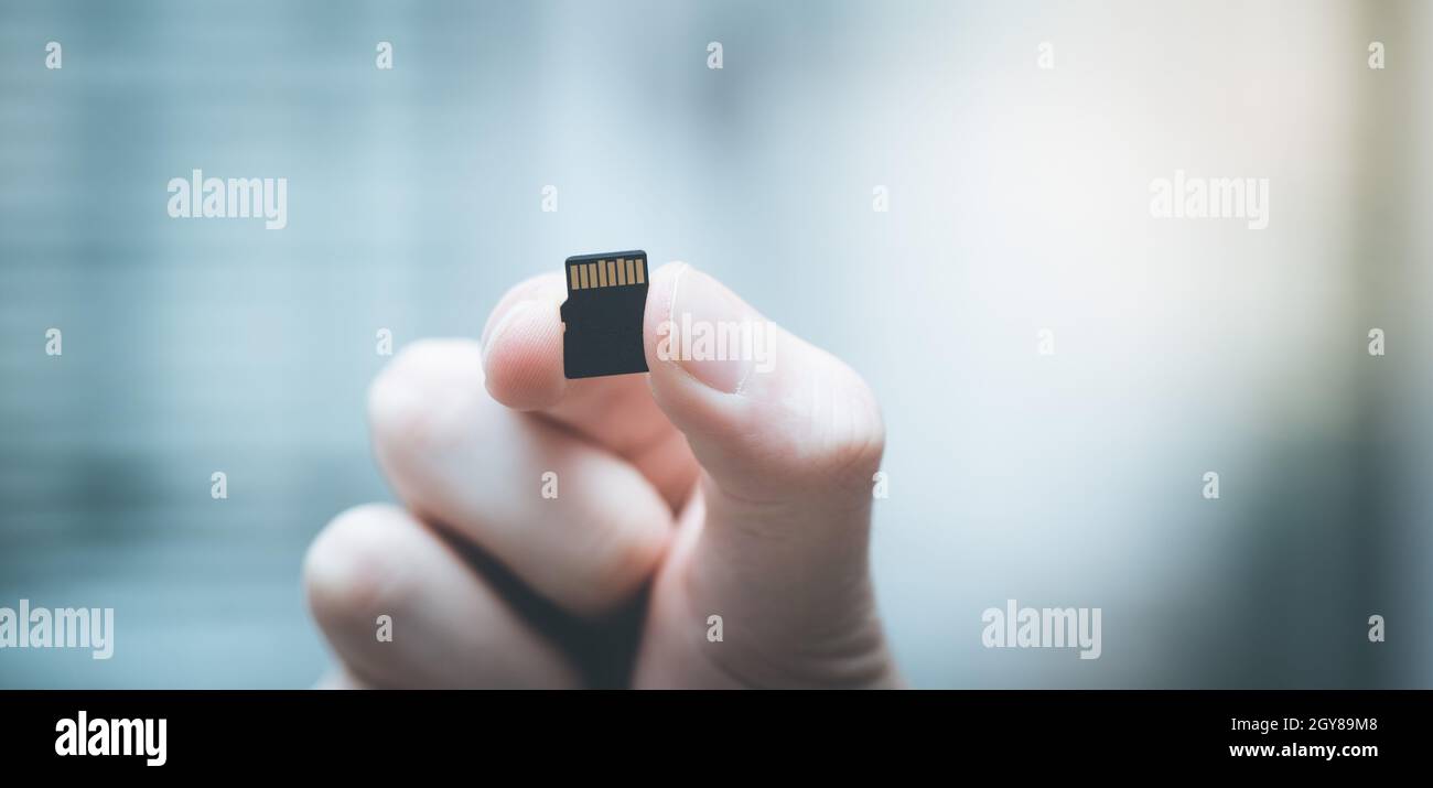 Young man is holding a tiny memory card in his hand, text space Stock ...