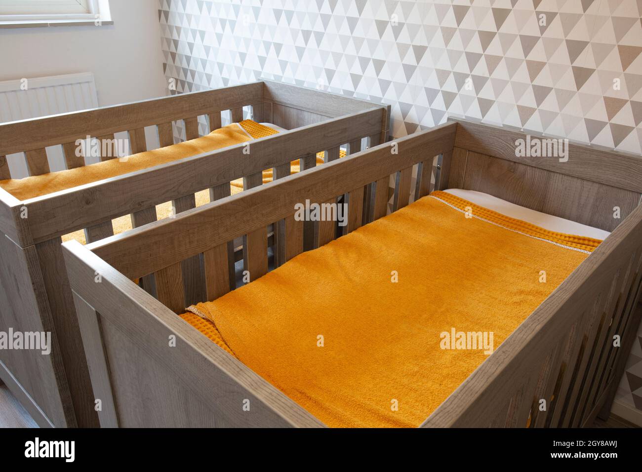 A Twin Bedroom with wooden baby beds for siblings, newborn babies