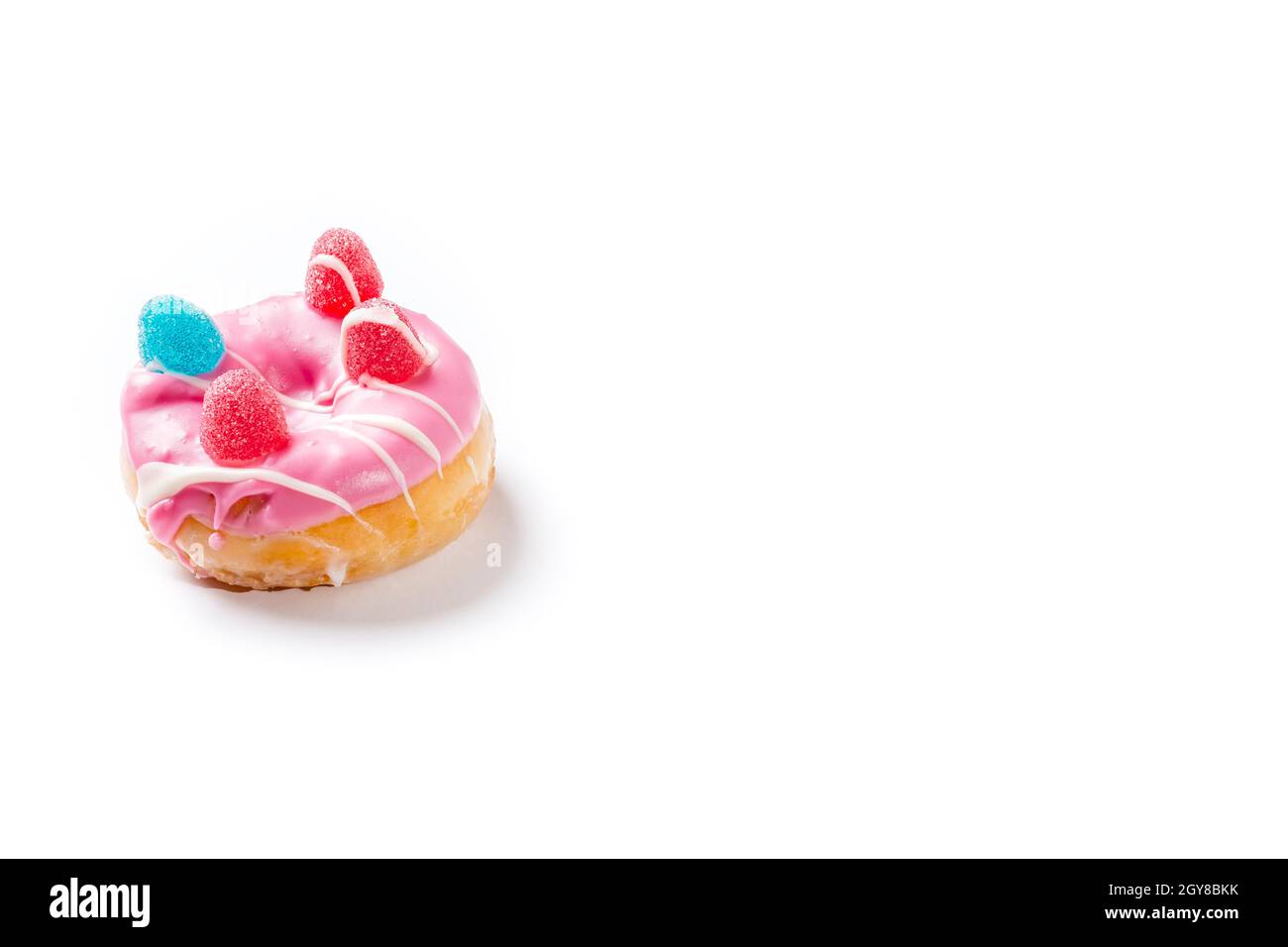 Photograph of a pink donuts painted with white chocolate and decorated with jelly beans.The photo is taken in horizontal format on a white background Stock Photo