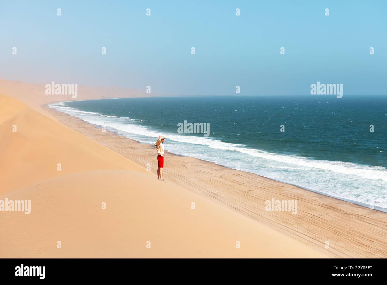 Single man in a cowboy hat in the Namib desert on Atlantic ocean background. Travel concept Stock Photo