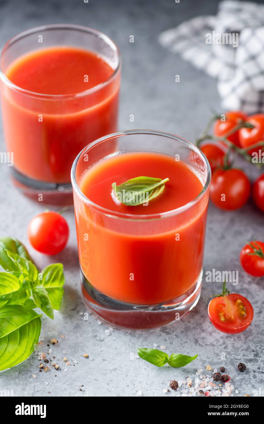 Tomato juice with salt and basil on concrete background. Healthy detox tomato juice Stock Photo