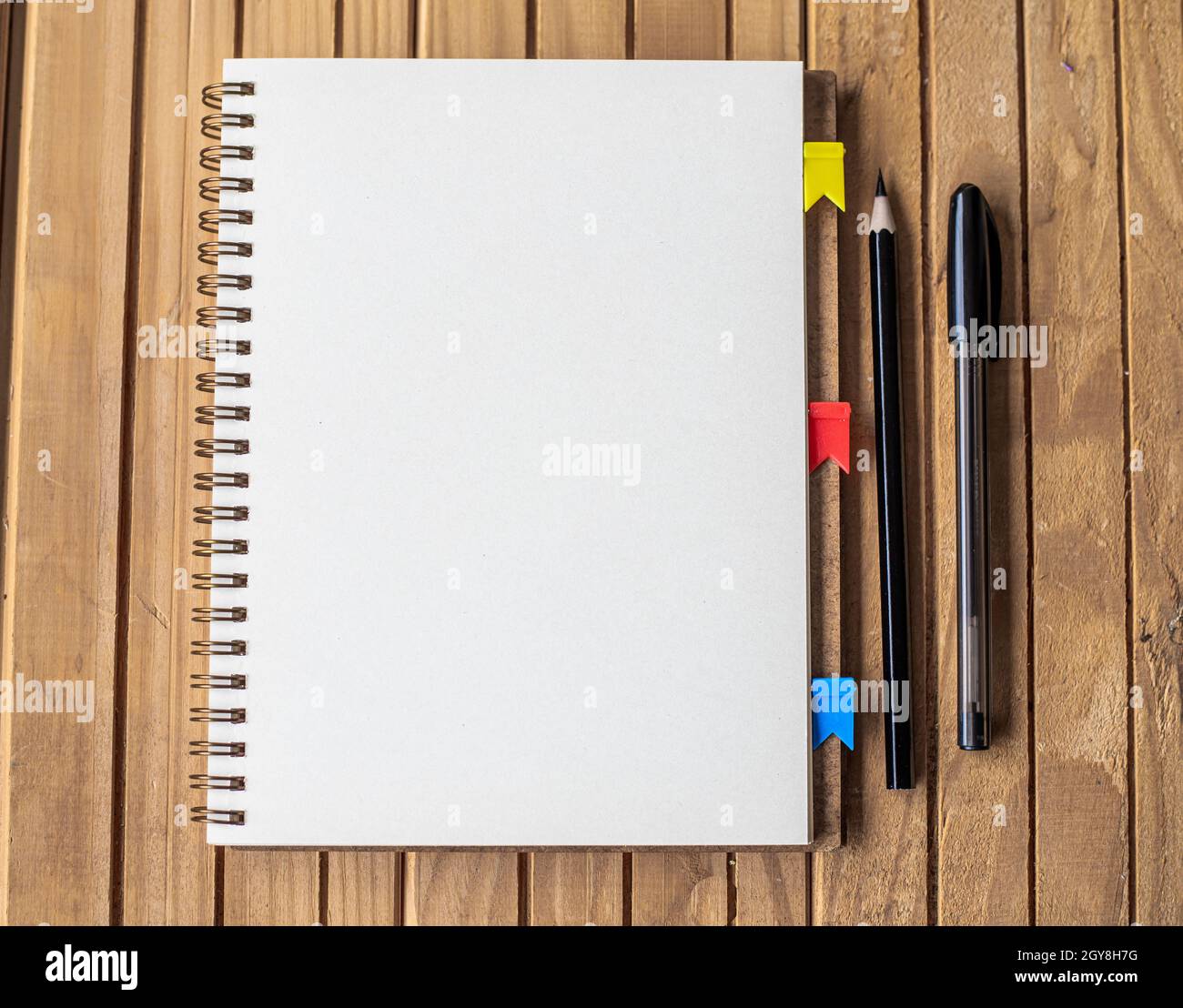 Blank Open Spiral Notebook With Diffrent Pens Placed On Table. Stock Photo