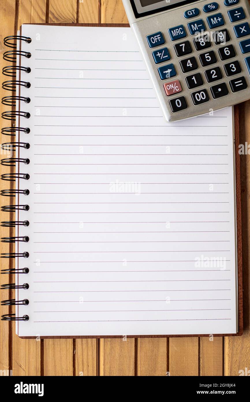 Blank Open Spiral Notebook With A Calculator Placed On Table. Stock Photo