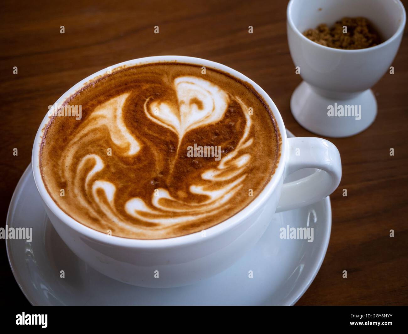 Coffee cup latte art on wood table Stock Photo - Alamy