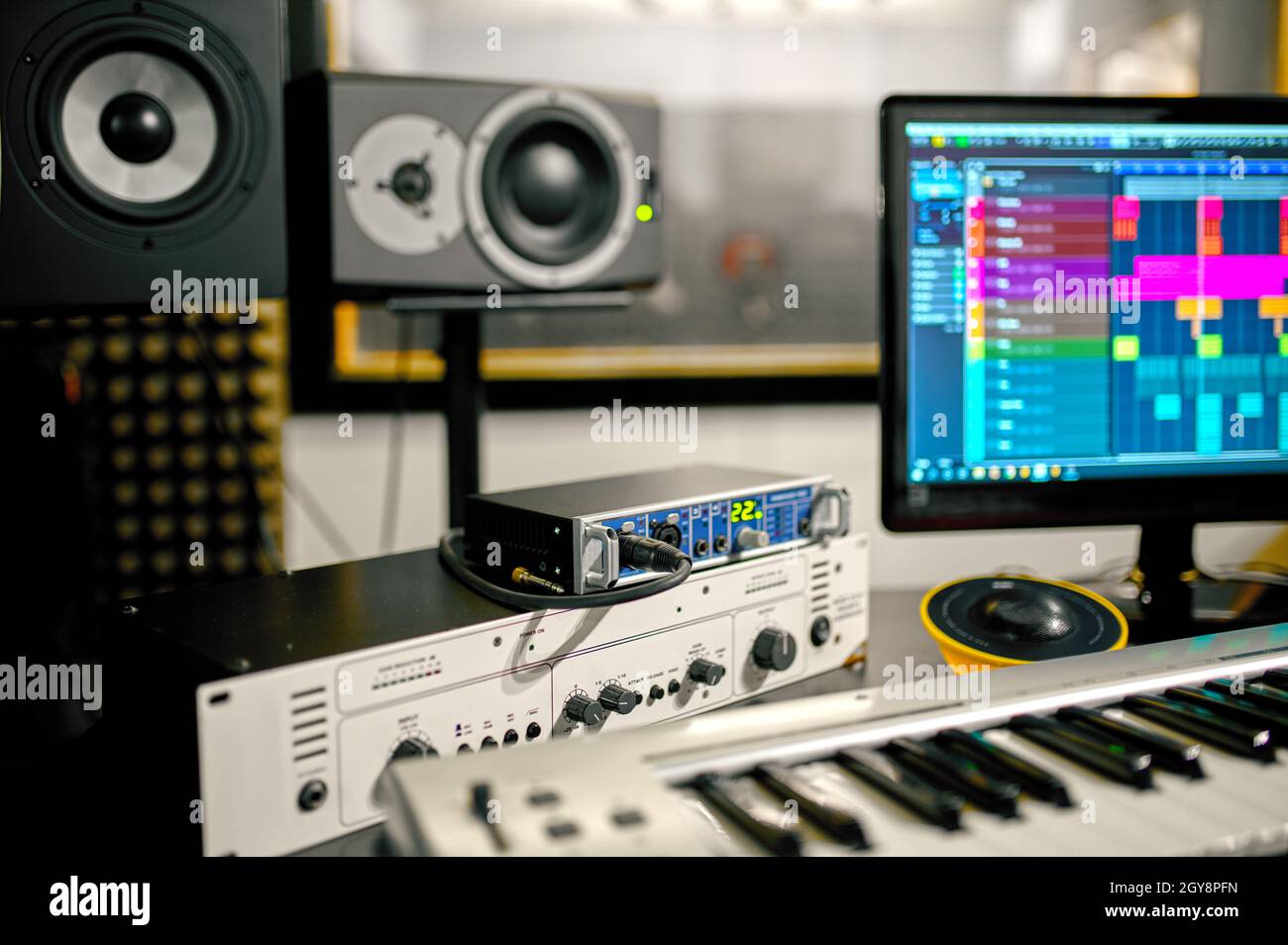 Synthesizer closeup, recording studio equipment on background. Audio speakers, mixer and monitor, sound engineer workplace Stock Photo