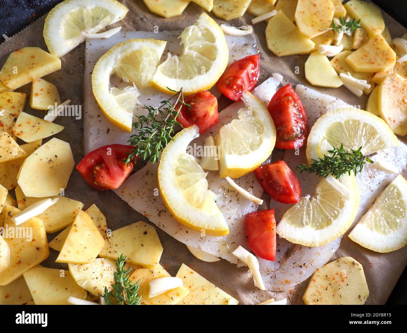 Cod fillet garnished with thyme, garlic and tomatoes, preparation of a