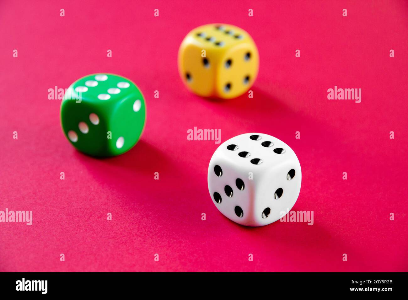 Three colorful dices isolated on pink background Stock Photo