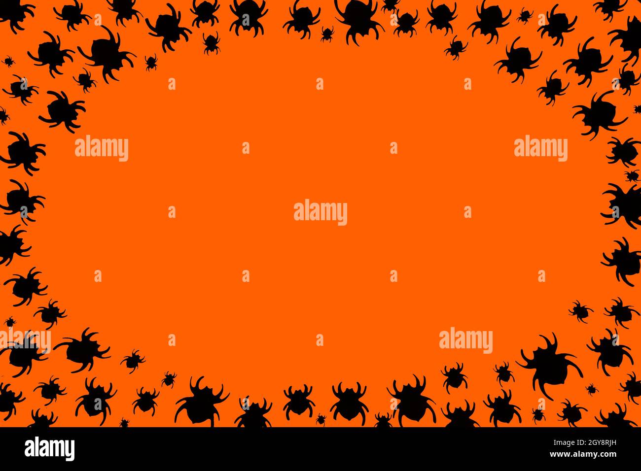 Scary orange background for Halloween. Black spiders running to the center surround. Place for the text in the center. Frame for holiday design. Stock Photo