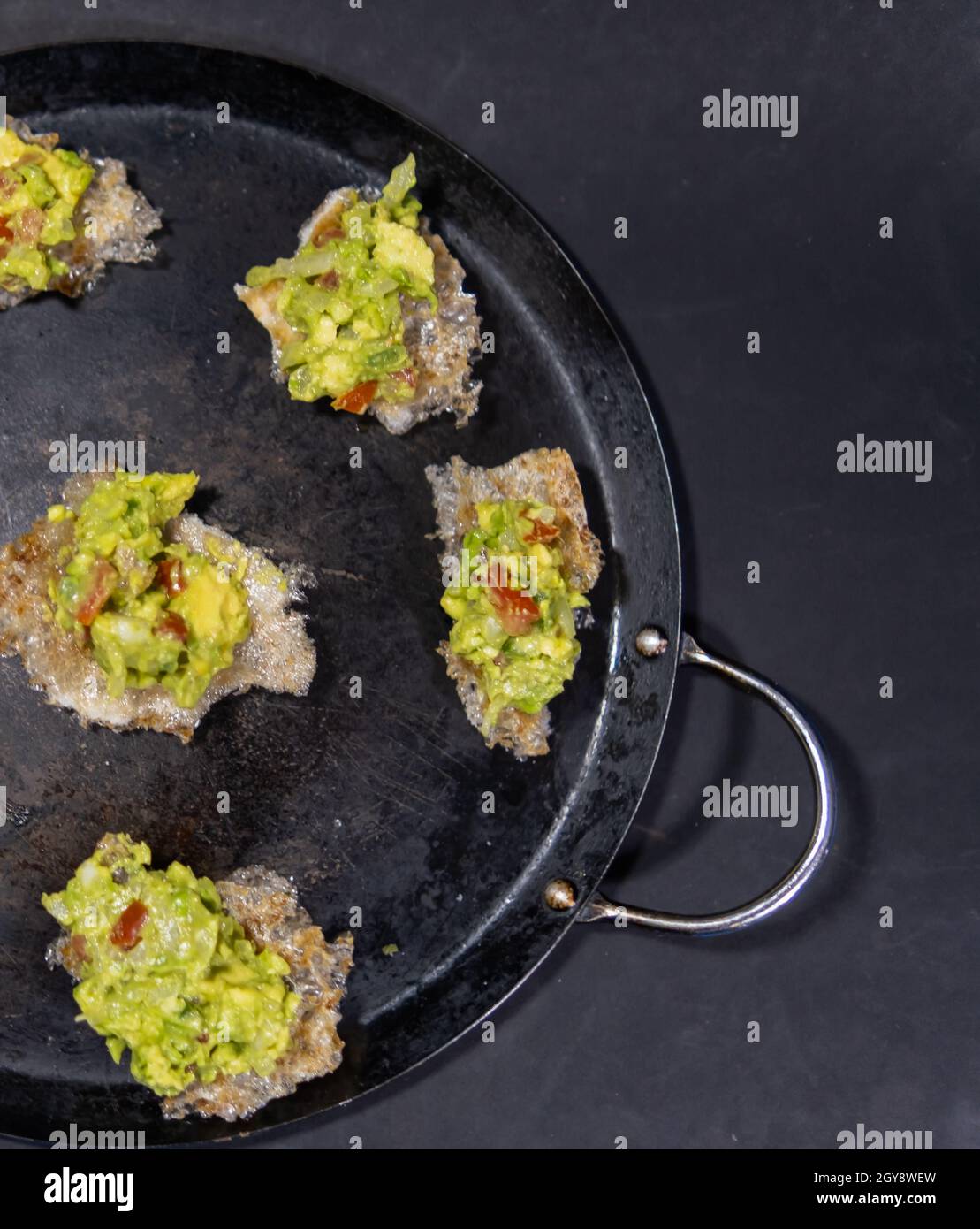 Pork rinds with guacamole on traditional Mexican comal Stock Photo Alamy