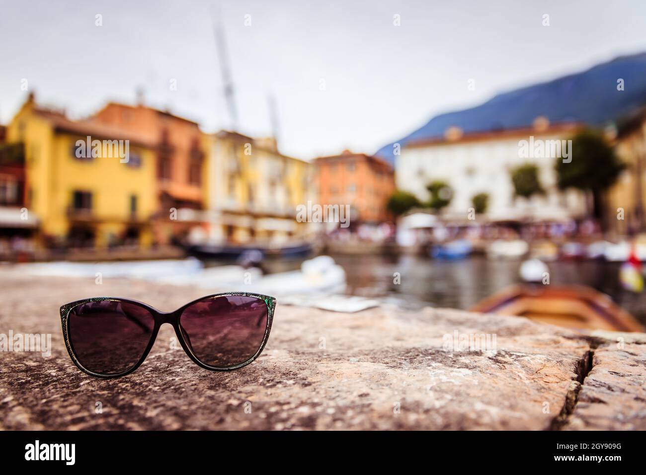 Italian harbour scene: Sunglasses on the stony ground Stock Photo - Alamy