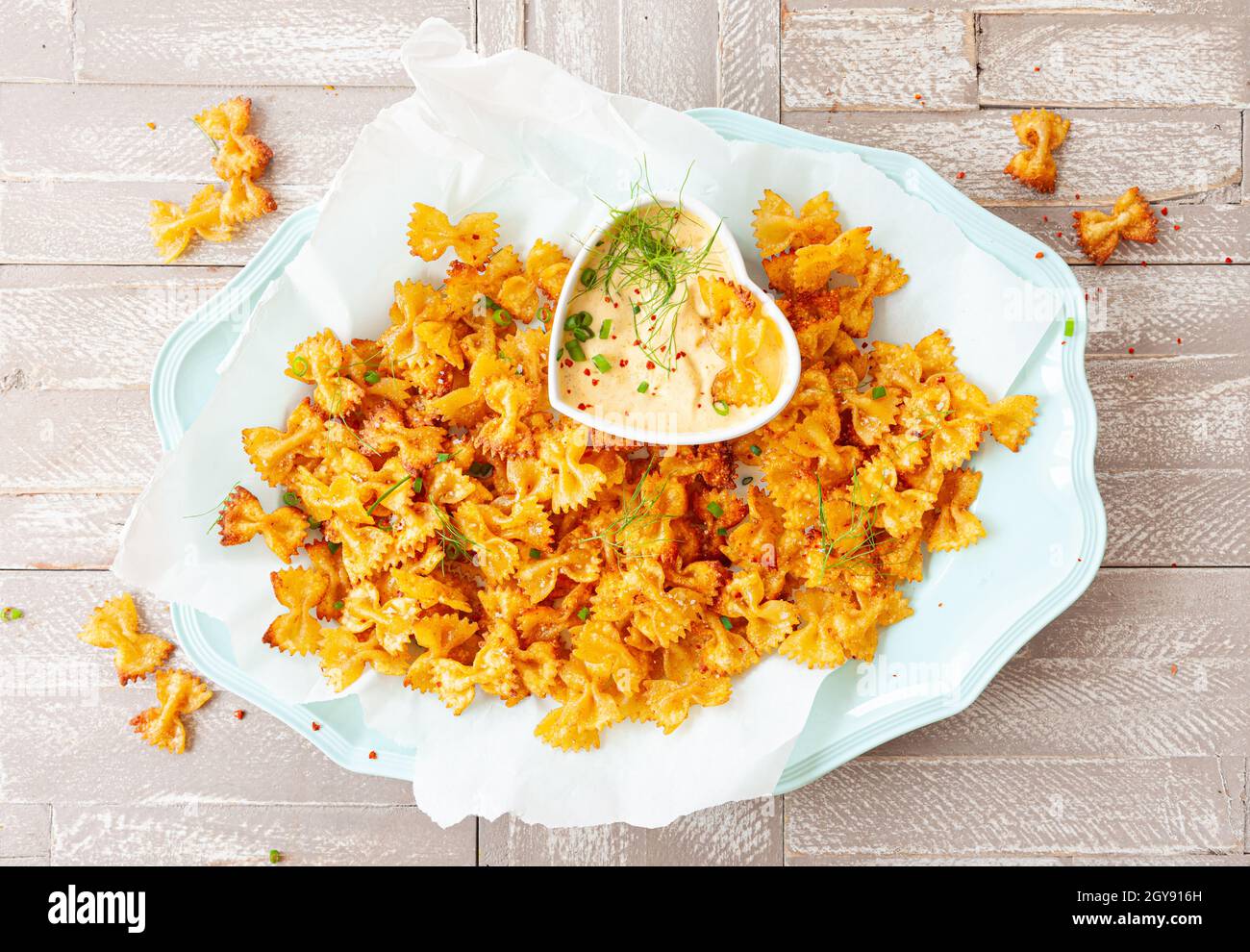 Spicy farfalle pasta chips with homemade herb dip Stock Photo