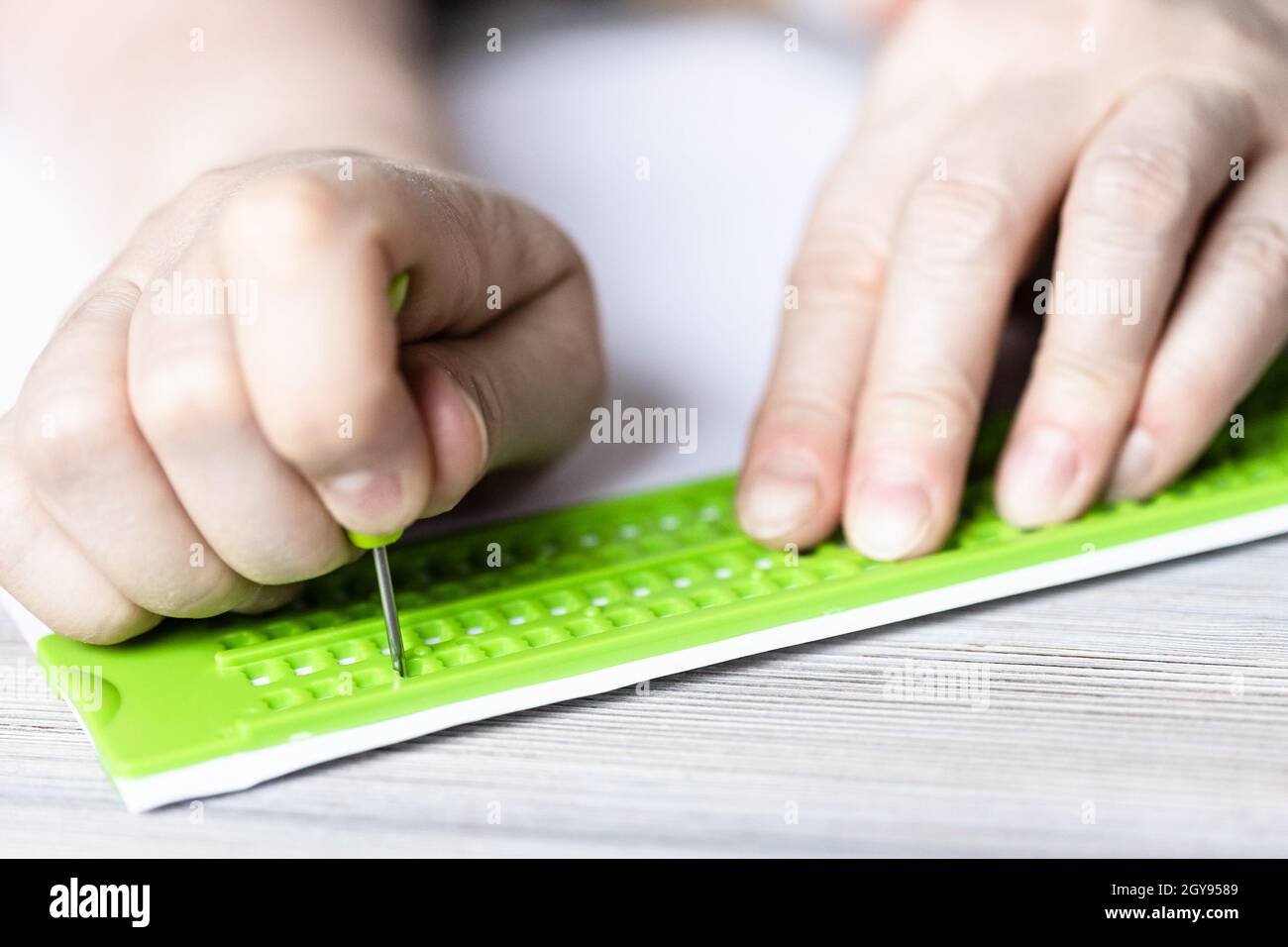 front view of writing in braille with slate and stylus close up Stock