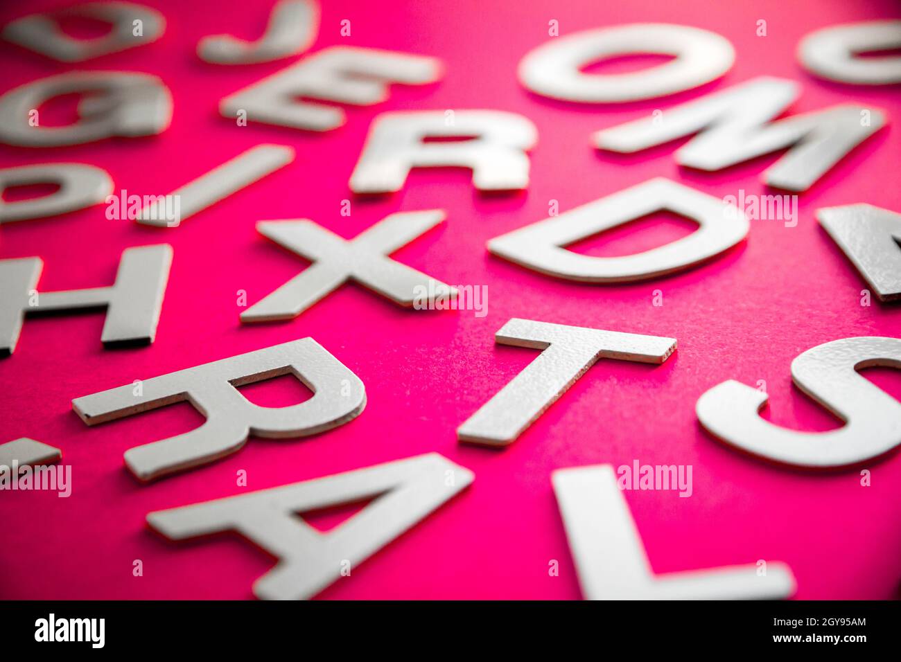 Mixed solid letters pile close up view photo. Education concept on pink ...