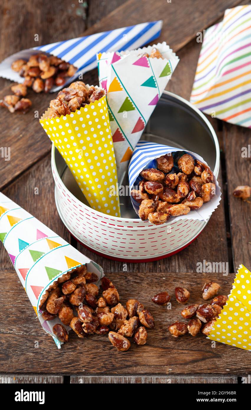 Sugar roasted almonds with cinnamon in little colorful paper bags Stock Photo