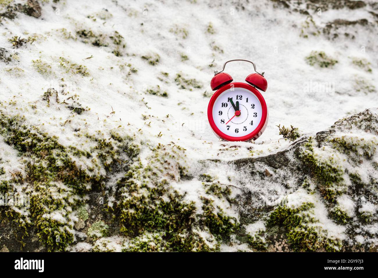 Time Freezing Clock Alarm clock on a snow covered rock. Time freezing concept Stock Photo ...