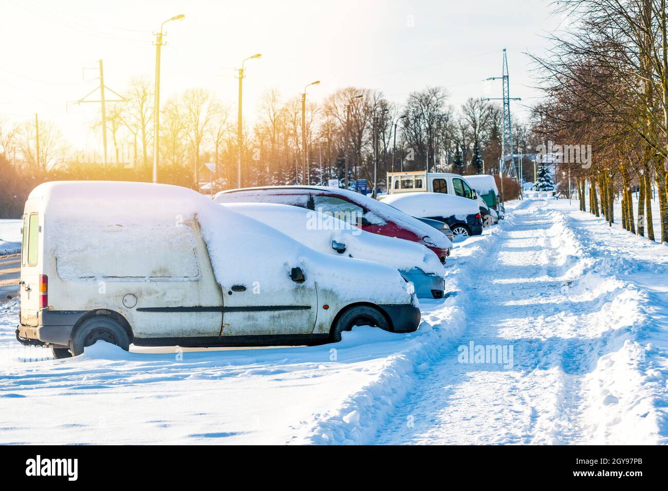 Parking lot with cars sunlit covered in fresh snow Stock Photo - Alamy