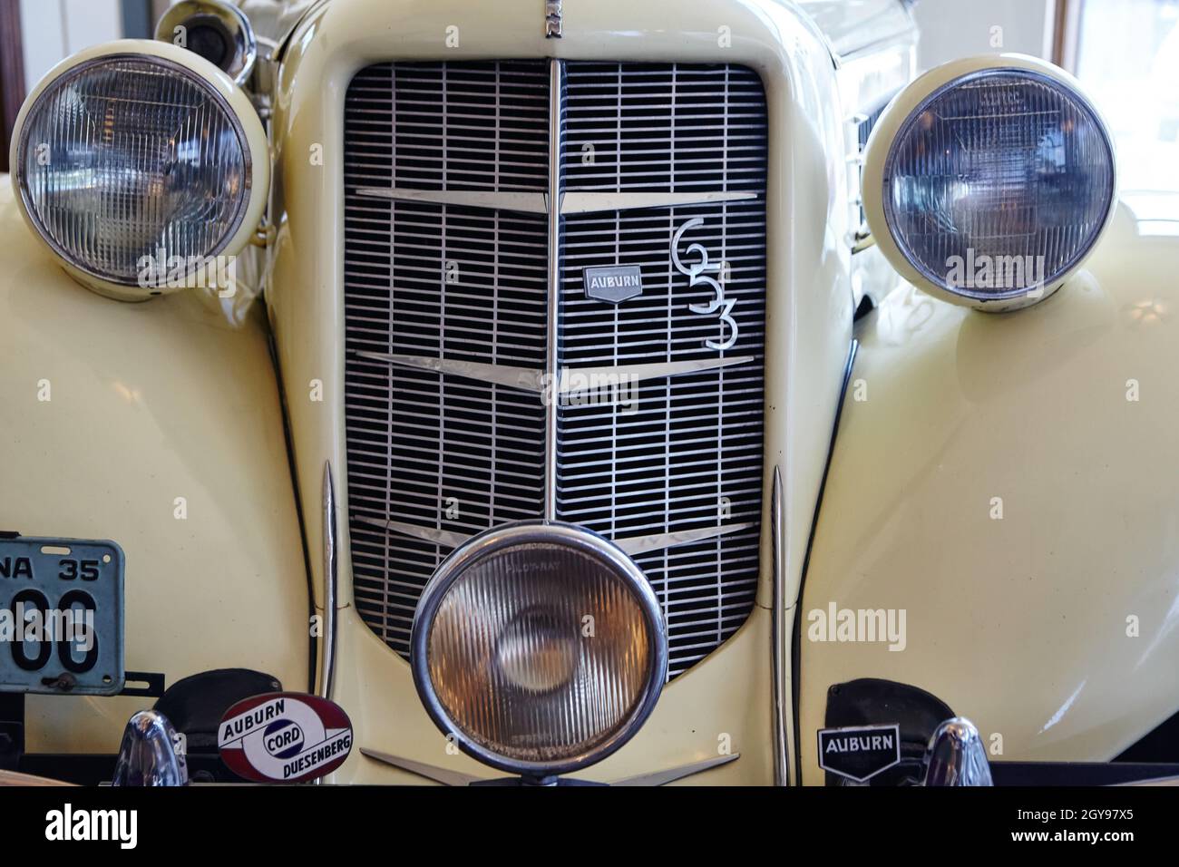 Close up front shot of an antique white car with a tall grill and two headlights like eyes Stock Photo