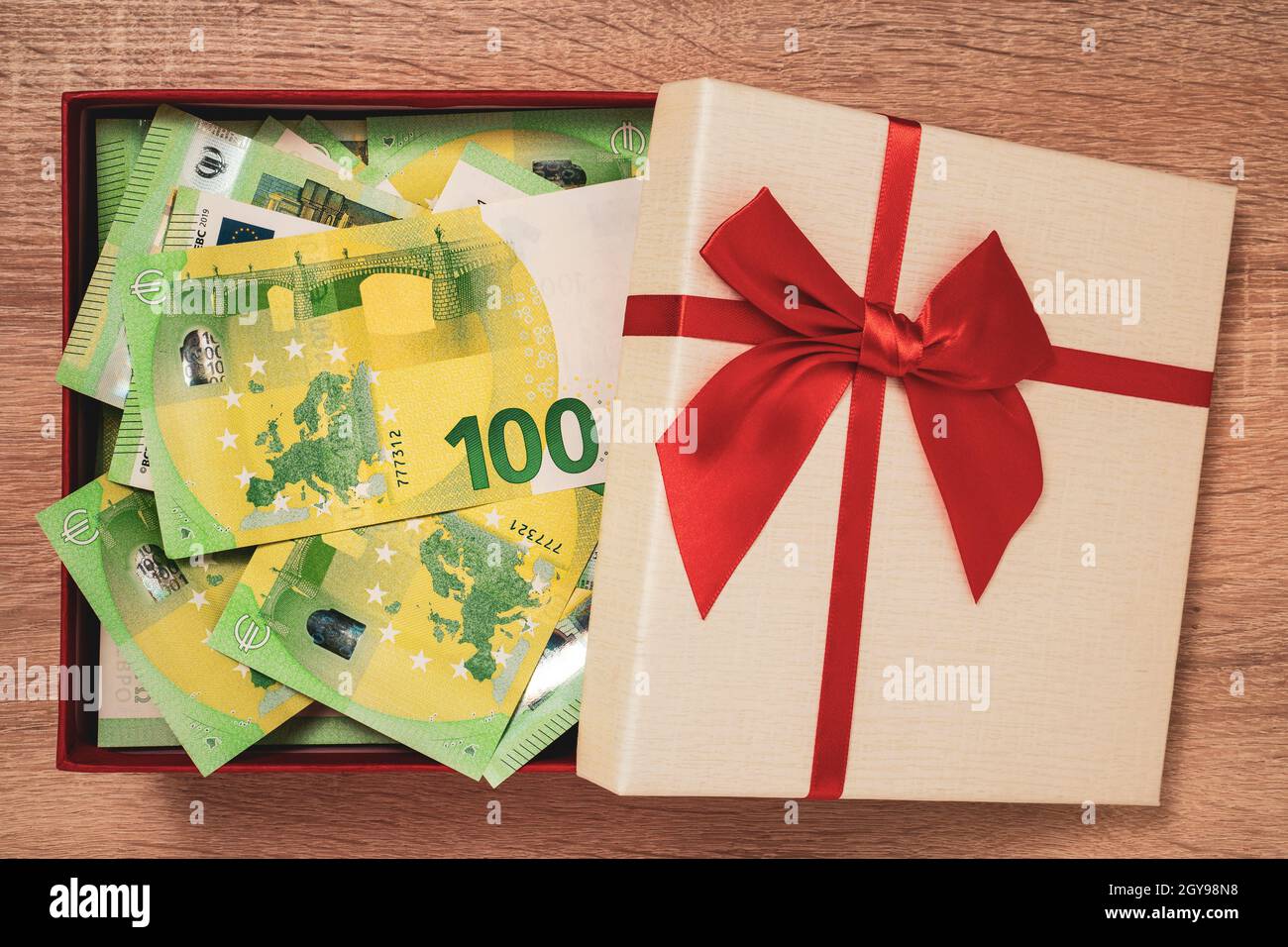 Open gift box full of money. Euro currency in the gift box with red