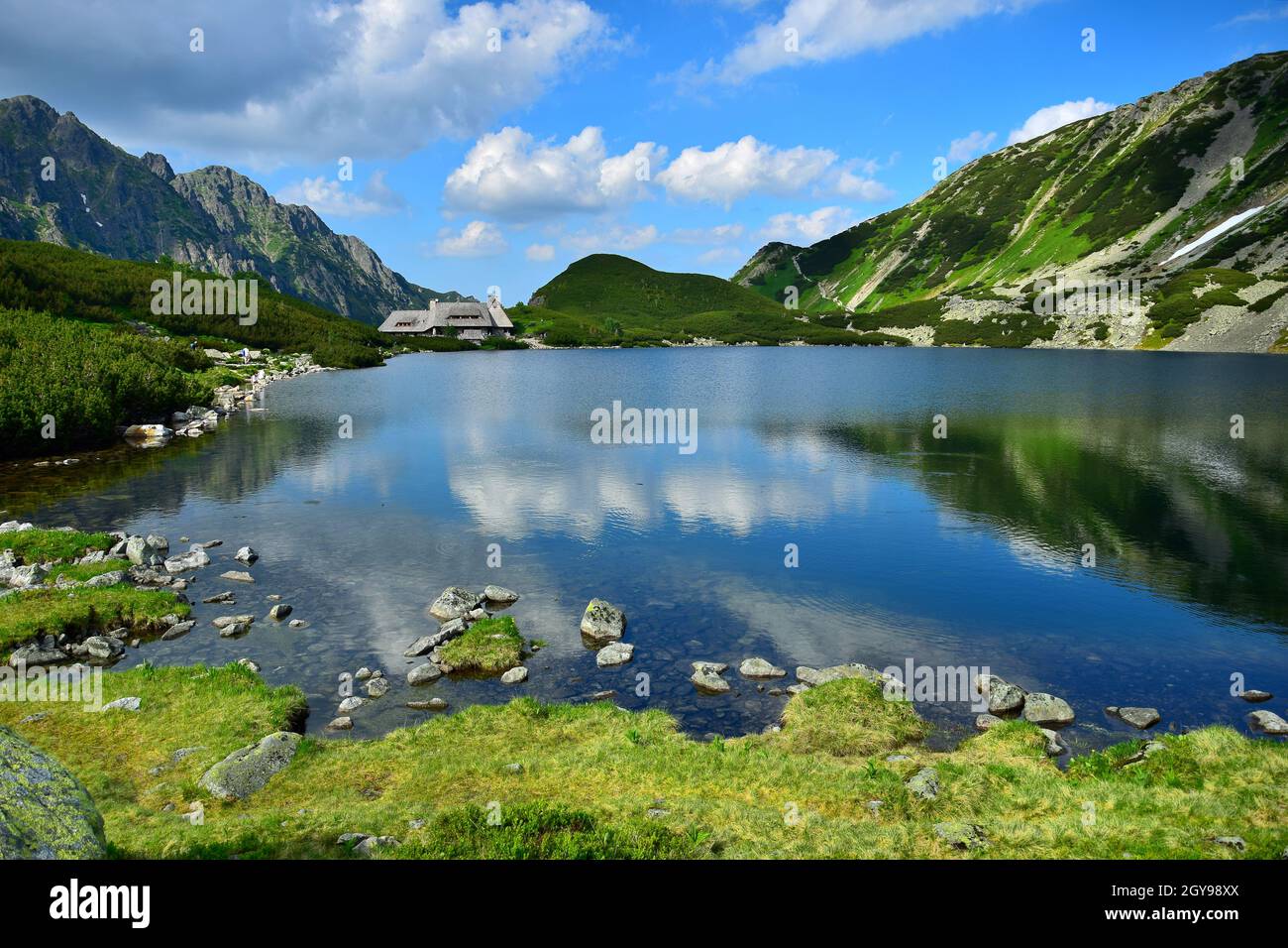 The beautiful lake Przedni Staw and the mountain lodge Schronisko Piec Stawow in the High Tatras, Poland. Stock Photo