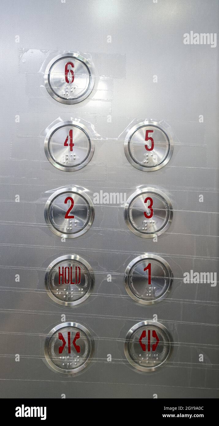 Elevator button with clear tape, easy for cleaning. Reduce the risk of infection cover-19. New normal concept. Stock Photo