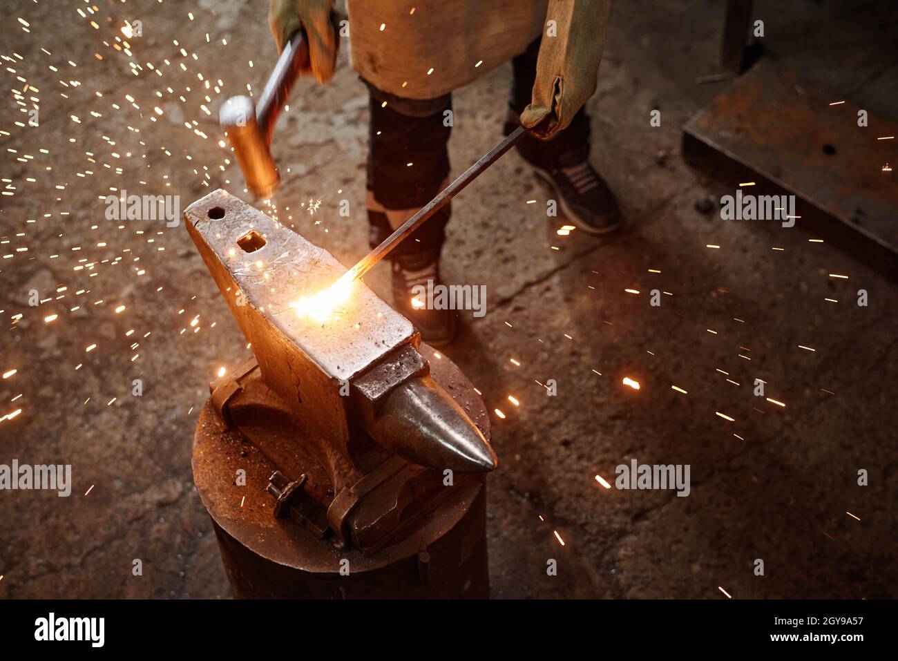 Close-up of blacksmith using work tool to forge the iron in the ...