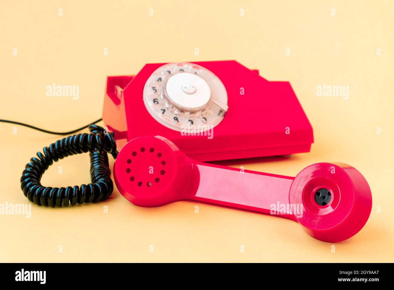 Old landline phone on yellow background. Hotline phone, call center, customer service help desk or contacts on site. Stock Photo