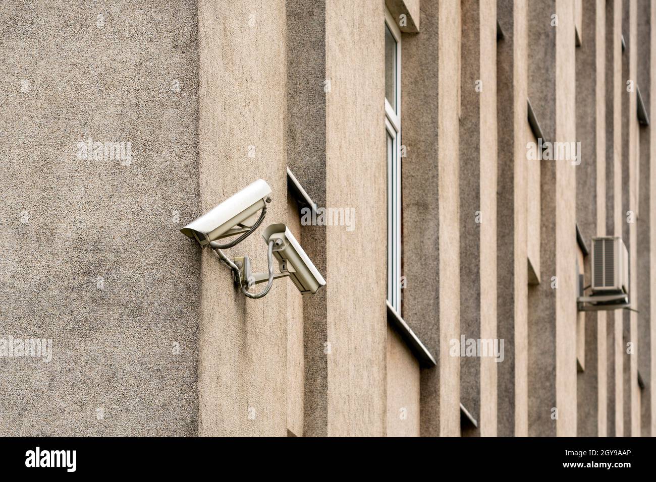 Two CCTV cameras on grey building wall. CCTV security system. Stock Photo