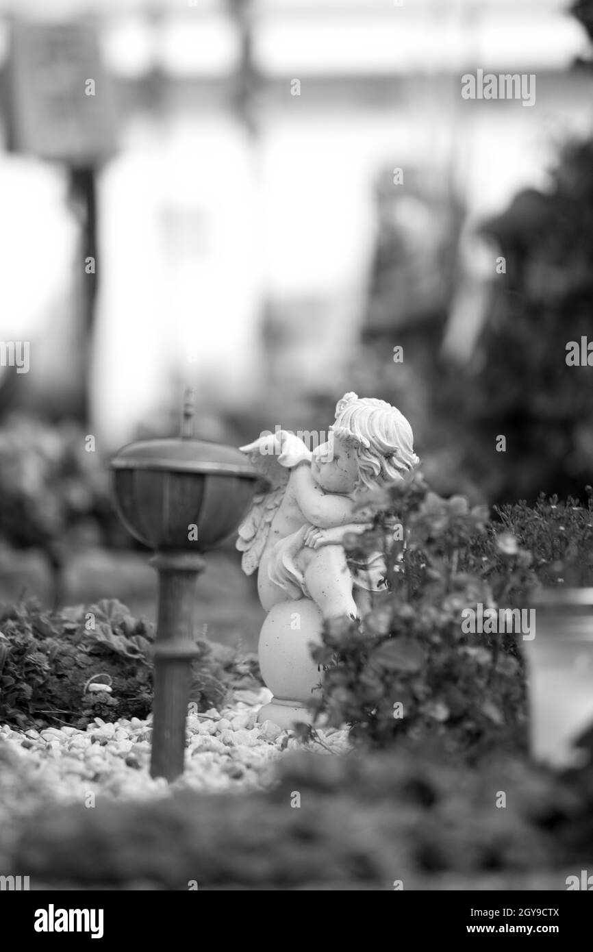 White angel on a grave at a cemetery, flowers Stock Photo