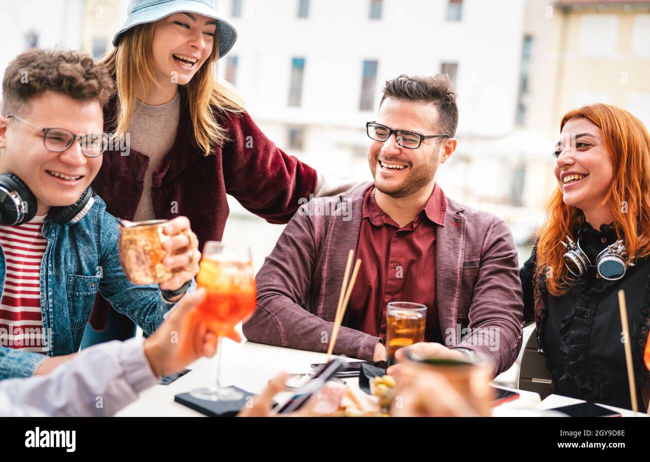 Friends having fun drinking at open air bar after work - Life style concept with young people enjoying time together sharing cocktails on happy hour Stock Photo