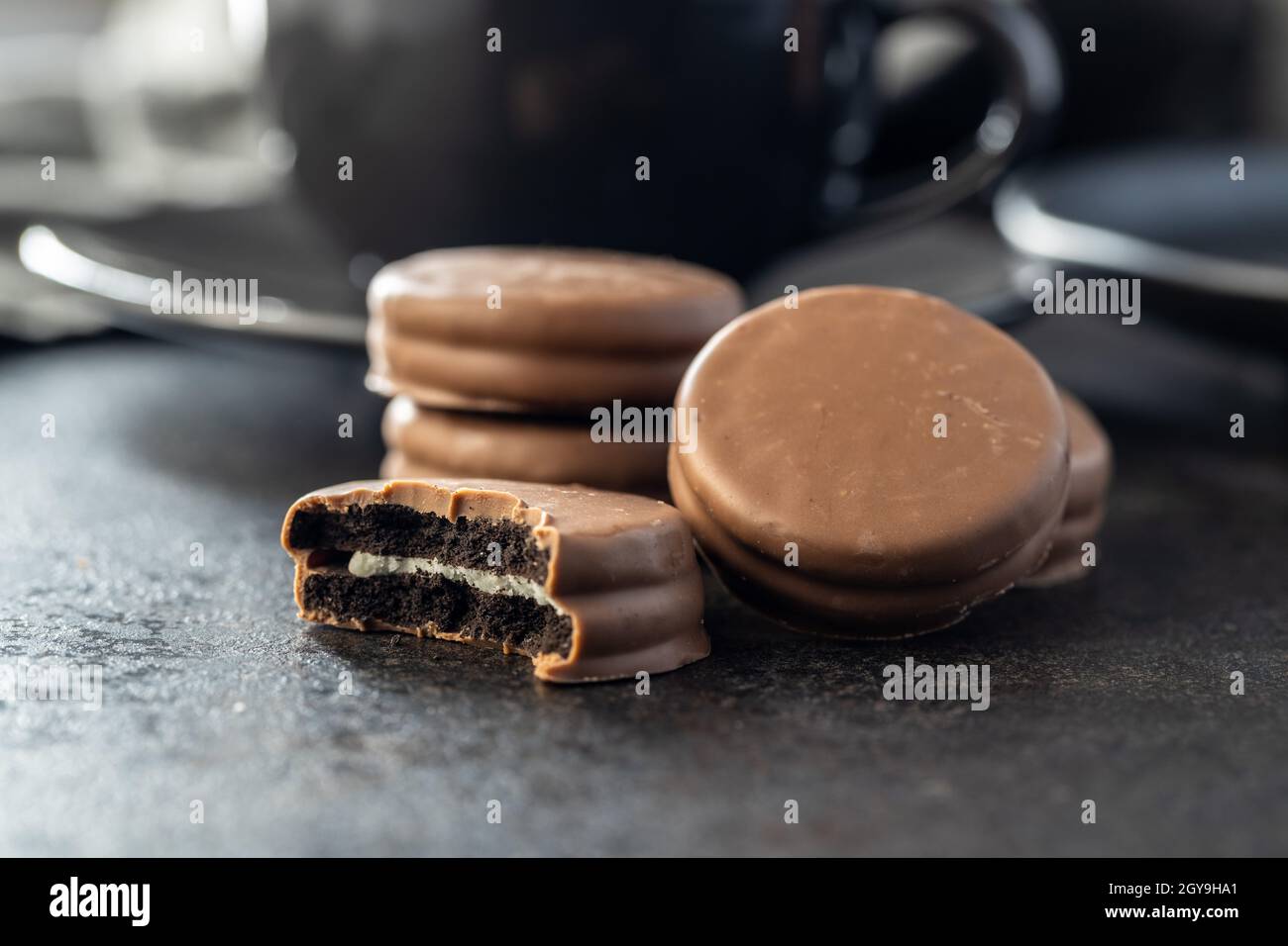 Biscuits with chocolate icing on black table. Stock Photo