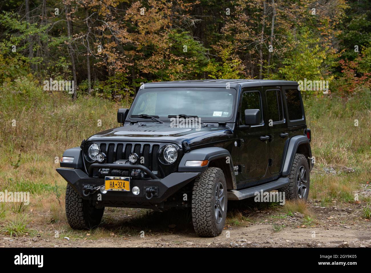 A black Jeep Wrangler Unlimited JL with a custom steel bumper, winch and  auxiliary lights parked in the Adirondack Mountains wilderness Stock Photo  - Alamy
