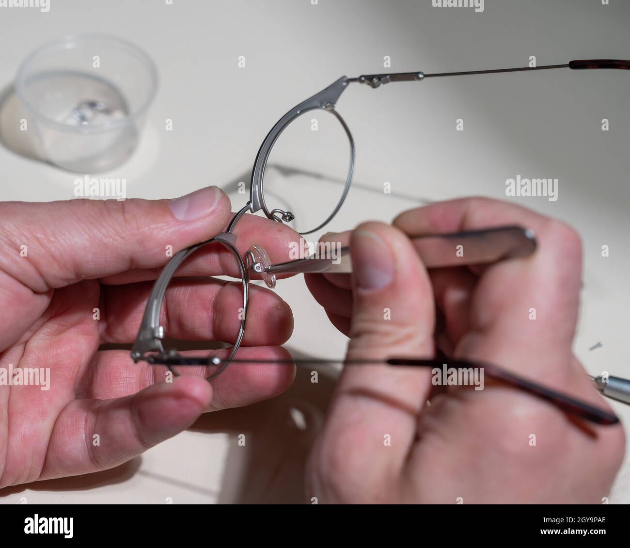 Installation of nose pads in glasses. A male technician repairs broken