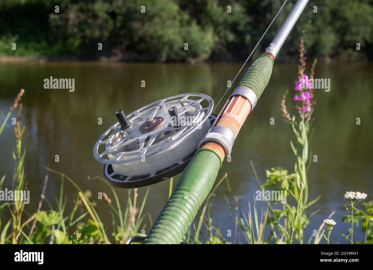 On the banks of the beautiful river over the water set fishing equipment to  fish comfortably with rod and reel Stock Photo - Alamy