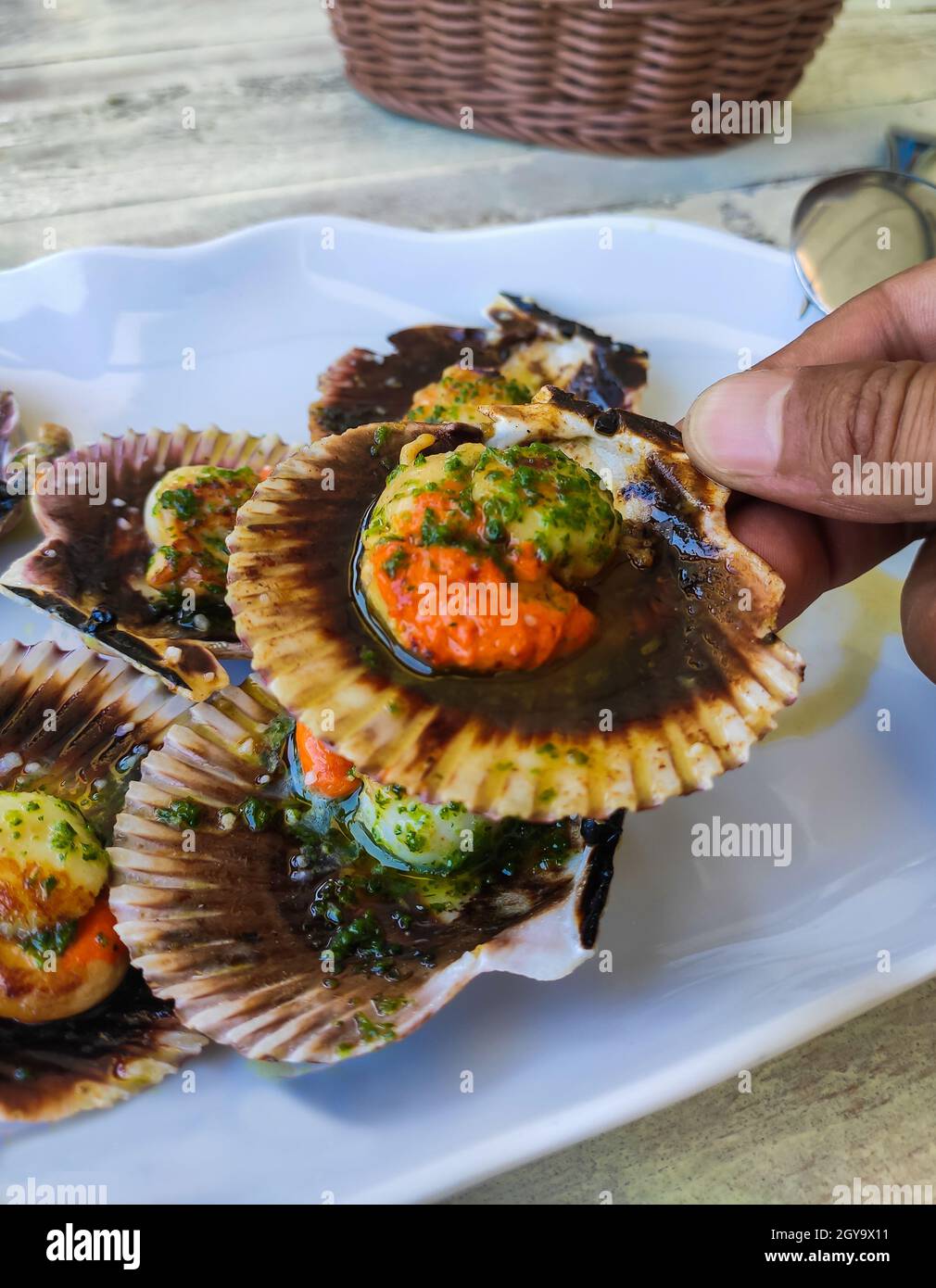 Hand holding scallops in restaurant ready to eat Stock Photo
