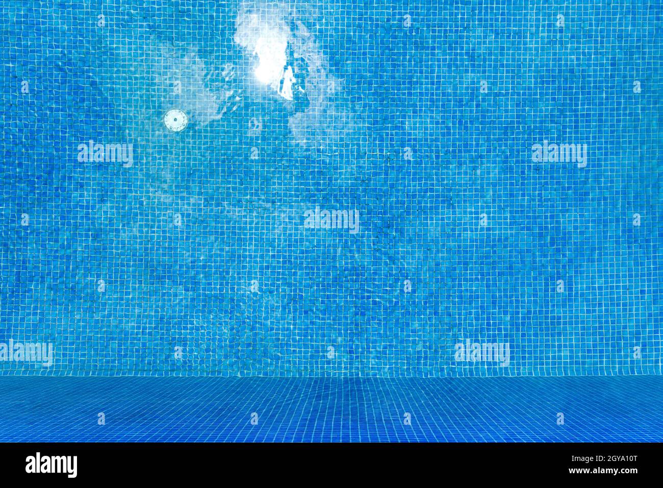 Top view of clear water in a blue tile swimming pool background. Stock Photo