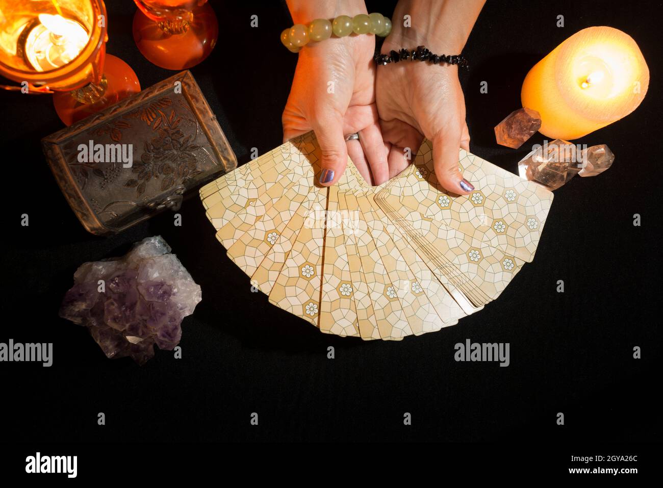 Detail of a woman's hands showing tarot cards. Concept of a fortune telling session with tarot cards. View from above. Stock Photo