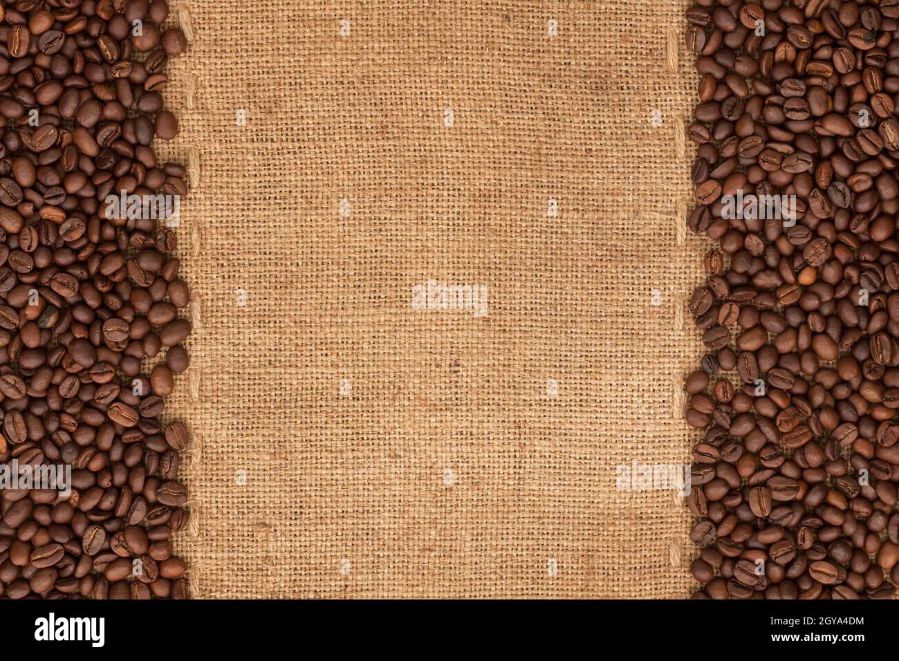 Coffee beans lying on sackcloth with space for text Stock Photo